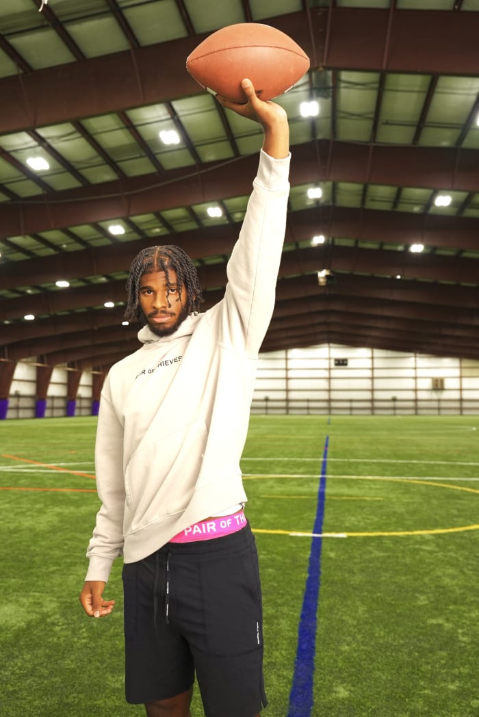 Shedeur Sanders holds a football in a photo shoot.